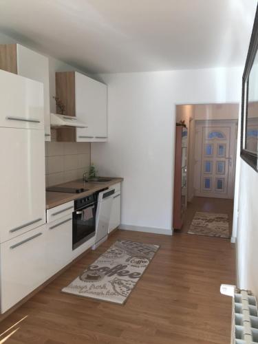 cocina con electrodomésticos blancos y suelo de madera en Apartment Pula, en Pula
