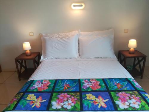a bedroom with a bed with two lamps on two tables at TAHITI - Condo Ariitea in Pirae