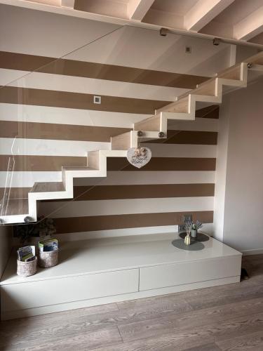a staircase in a living room with brown and white stripes at Borgo&Lago Home in Castro