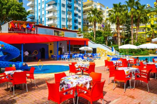 een restaurant met tafels en stoelen en een zwembad bij Ark Apart and Suite Hotel in Alanya