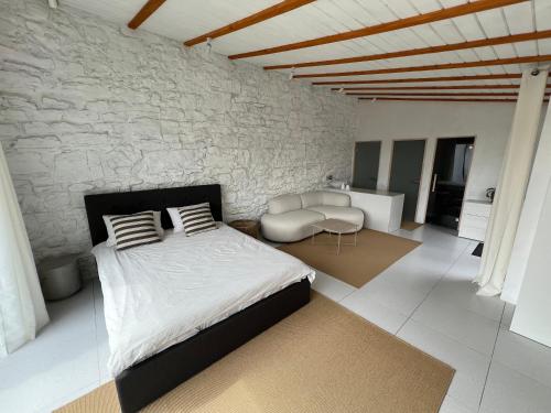 ein Schlafzimmer mit einem Bett und einer Steinwand in der Unterkunft Tatsopus in Kamjanez-Podilskyj