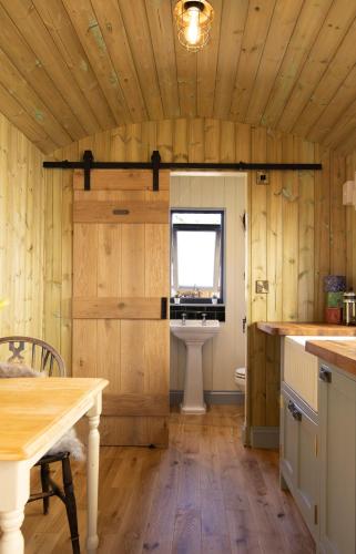 a kitchen with wooden walls and a table and a window at Valentine in Longdown