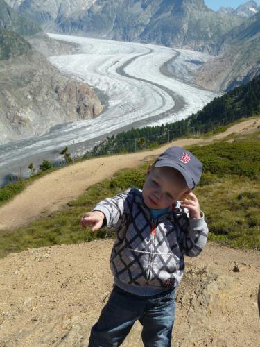 a young boy standing on a hill near a river at Chalet Enzian in Riederalp