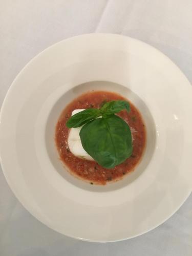 a white plate with a dish of food on a table at Castello Oldofredi in Monte Isola