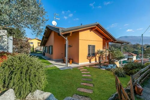 a small yellow house with a yard at Villa Laura Private Pool and Garden near Lake Maggiore for 9 - Happy Rentals in Besozzo