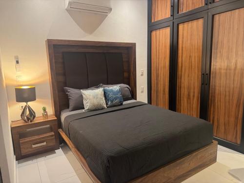 a bedroom with a large bed and a night stand at Orion department in Tepic