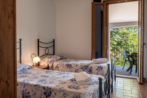a bedroom with three beds and a balcony at Capracotta in Montemassi