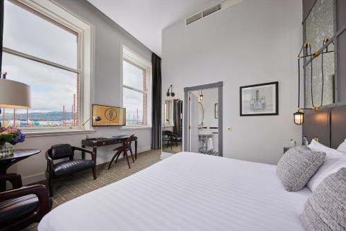 una stanza d'albergo con un letto, una scrivania e delle finestre di Titanic Hotel Belfast a Belfast