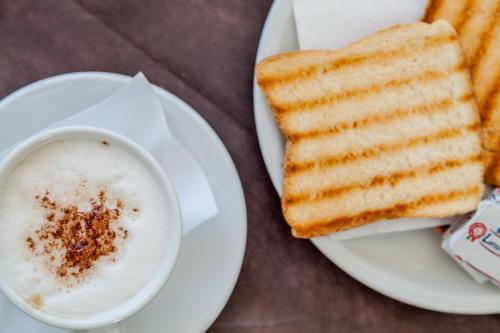 a plate with toast and a cup of coffee at Hotel El Balear in Alghero