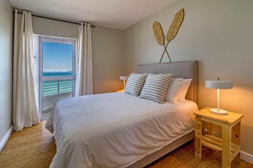 a bedroom with a large bed with a view of the ocean at 75 Cap D'Azur in Strand