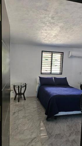 a bedroom with a blue bed and a table at Villa Privada 1200m2 Laguna a Pasos Pet Friendly in Xul-Ha