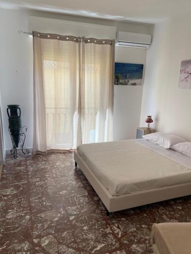 a bedroom with a bed and a large window at Gemma's Apartments in Mazzeo
