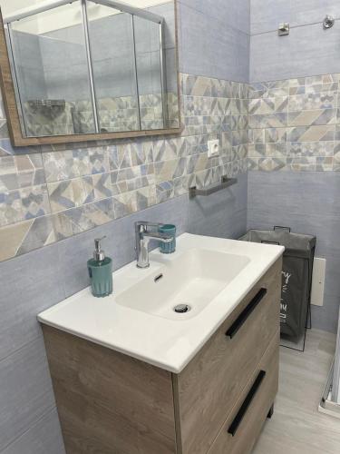 a bathroom with a sink and a mirror at Gemma's Apartments in Mazzeo