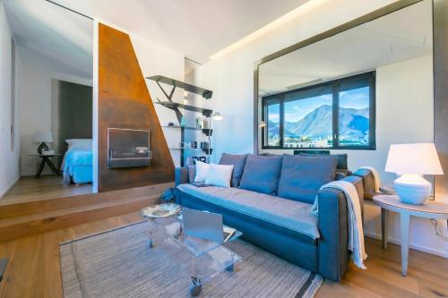 a living room with a blue couch and a table at Casa Basilico with Lake View and Private Garage - Happy Rentals in Lugano