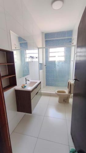 a bathroom with a toilet and a sink and a shower at Apê d'praia 31 - Beira Mar Bertioga in Bertioga