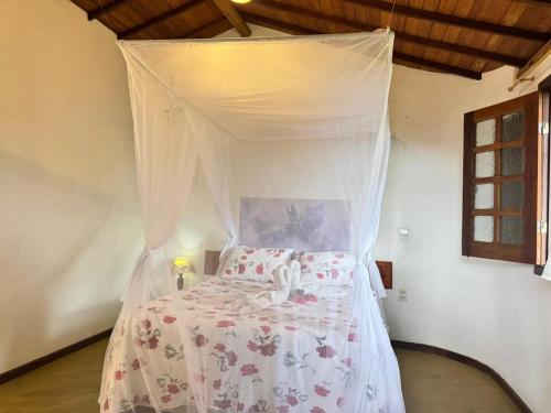 a bed with a canopy in a room at Pousada Aldeia in Ilha de Boipeba