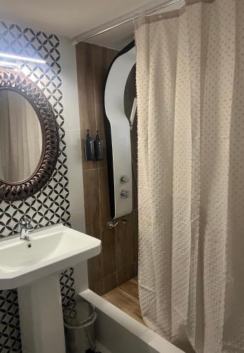 a bathroom with a shower with a sink and a mirror at La Terra Luxury apartment in Kiveri