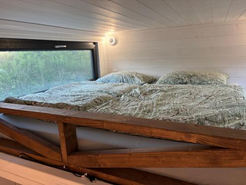 a bed in a tiny house with a window at Tinyhouse Na Zemi in Žďár nad Sázavou