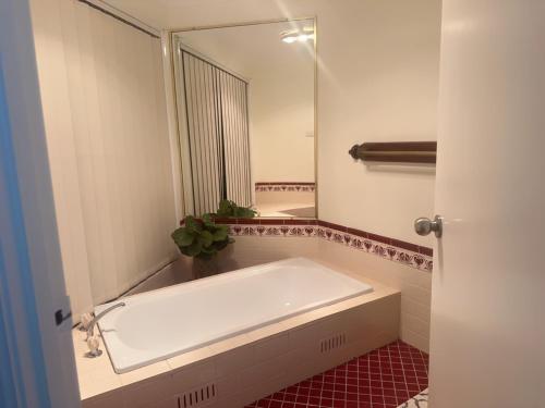 a bathroom with a tub and a large mirror at Private Rm3 with Queen bed in Elderslie