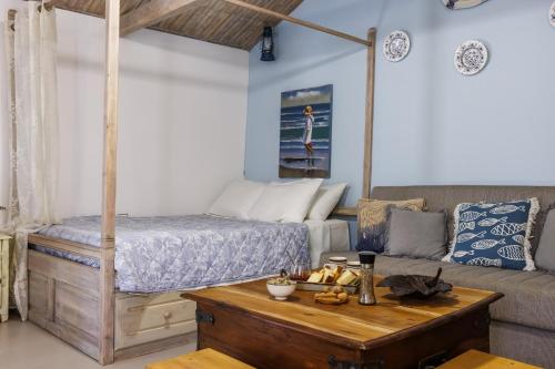 a living room with a bed and a coffee table at Yianna Cottage Studios in Skopelos Town