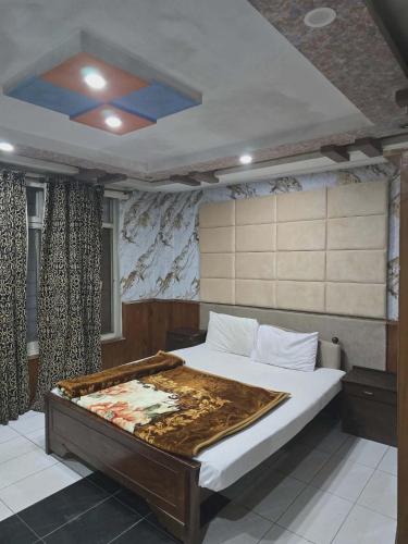 a bedroom with a large bed with a blue ceiling at Mughal E Azam Hotel in Murree