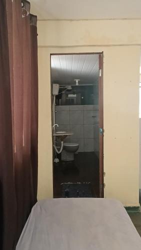 a view of a bedroom with a bed and a bathroom at Pousada Cantinho e Sossego casa 5 in Vespasiano