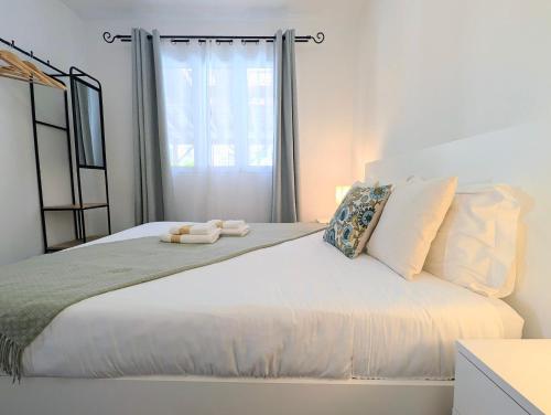 a bedroom with a large white bed with a window at Villa Herédia - 5 min form the beach in Ribeira Brava