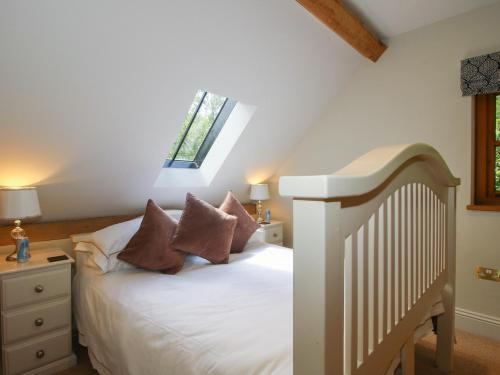 a bedroom with a white bed and a window at Pultheley Cottage in Montgomery