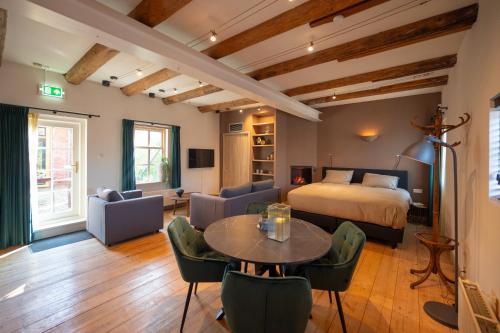 a bedroom with a bed and a table and chairs at Herberg In de Valk in Middelstum