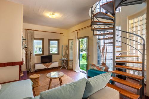 a living room with a spiral staircase in a house at Villa Portoblue Pearl in Pefkochori