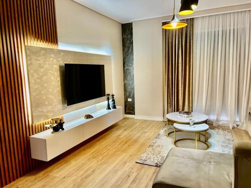 a living room with a tv and a couch and a table at Your Home Fier 2 in Fier