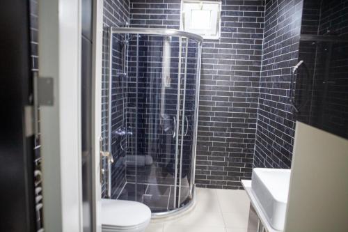 a black tiled bathroom with a toilet and a shower at Kemer Suit Residence in Kemer