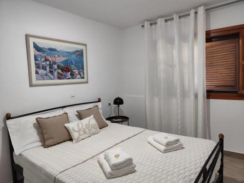 a bedroom with a bed with towels on it at Νέος Πύργος Family Home in Neos Pirgos