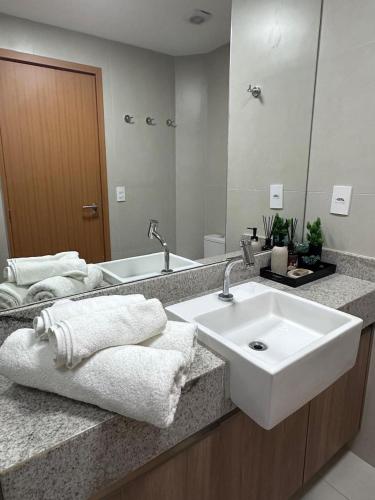 a bathroom with a white sink and a mirror at Flat com vista linda Eco Resort in Tamandaré
