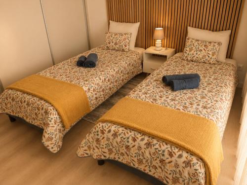two beds sitting next to each other in a room at Douro Garden in Resende