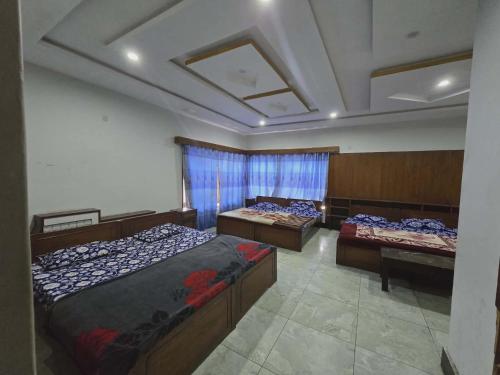 a room with three beds and a ceiling at Nice Guest House GPO Murree in Murree