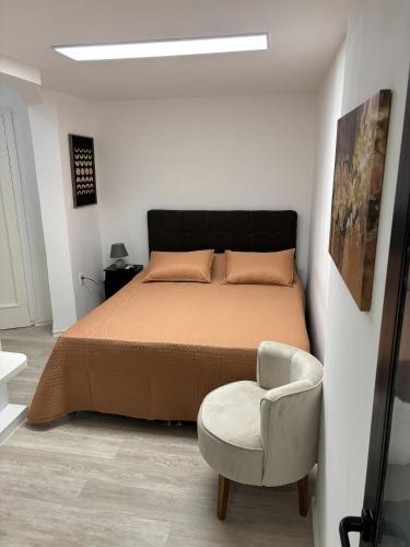 a bedroom with a bed and a chair at Montevideo Centro in Montevideo