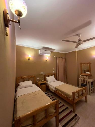 ein Schlafzimmer mit zwei Betten und einem Deckenventilator in der Unterkunft KR Elite Hotel in Luxor