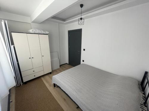 a bedroom with a bed and a white cabinet at Duplex Villa with Panoramic Sea View in Gokceada Town