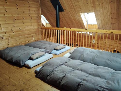 a room with three sleeping bags on the floor at Siodomi Marinki shared wood lodge, pets allowed for a fee in Ōkuki