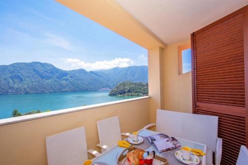 a table and chairs with a view of a lake at Como Lake Modern Apartament Ulivi in Mezzegra