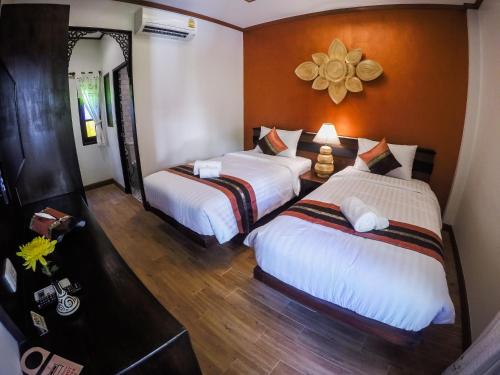 a bedroom with two beds and a mirror at i Lanna House in Chiang Mai