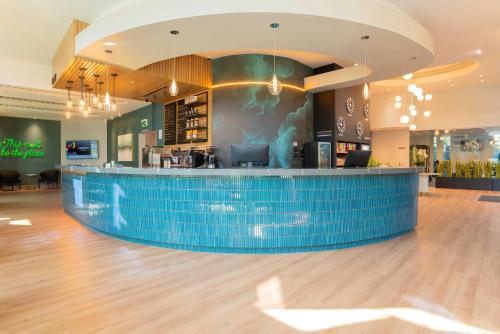 a bar in a restaurant with a blue tile counter at Sandman Signature Surrey-Guildford Suites in Surrey