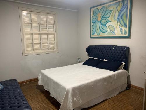 a bedroom with a bed and a painting on the wall at Casa completa com vaga de garagem 2 quartos in Campinas