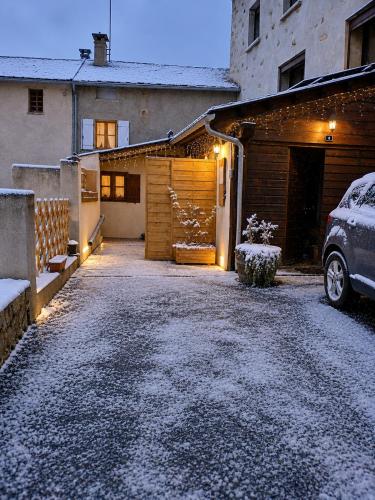 a driveway with a garage with snow on the ground at Maisonnette Cosy in La Llagonne