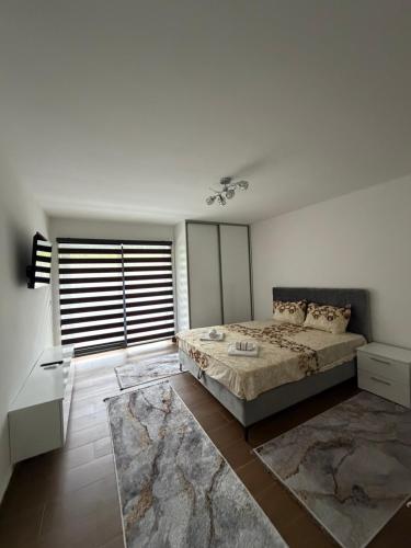 a bedroom with a large bed and a large window at Forest View Villa in Ilijaš