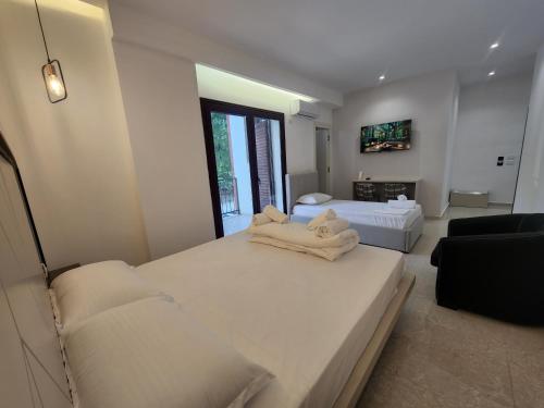 a bedroom with two beds and a living room at Eden Rooms in Vlorë