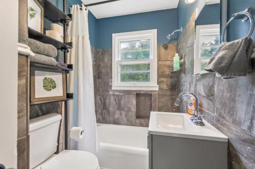 a bathroom with a sink and a toilet and a tub at Chic Home with Huge Grassy Yard 7 mins to Arrowhead Stadium in Independence