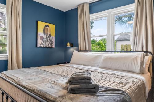 a bedroom with blue walls and a bed with towels on it at Chic Home with Huge Grassy Yard 7 mins to Arrowhead Stadium in Independence