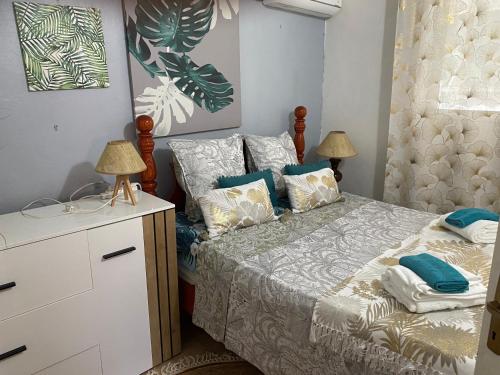a bedroom with a bed with blue and white pillows at Bleu Ocean in Deshaies